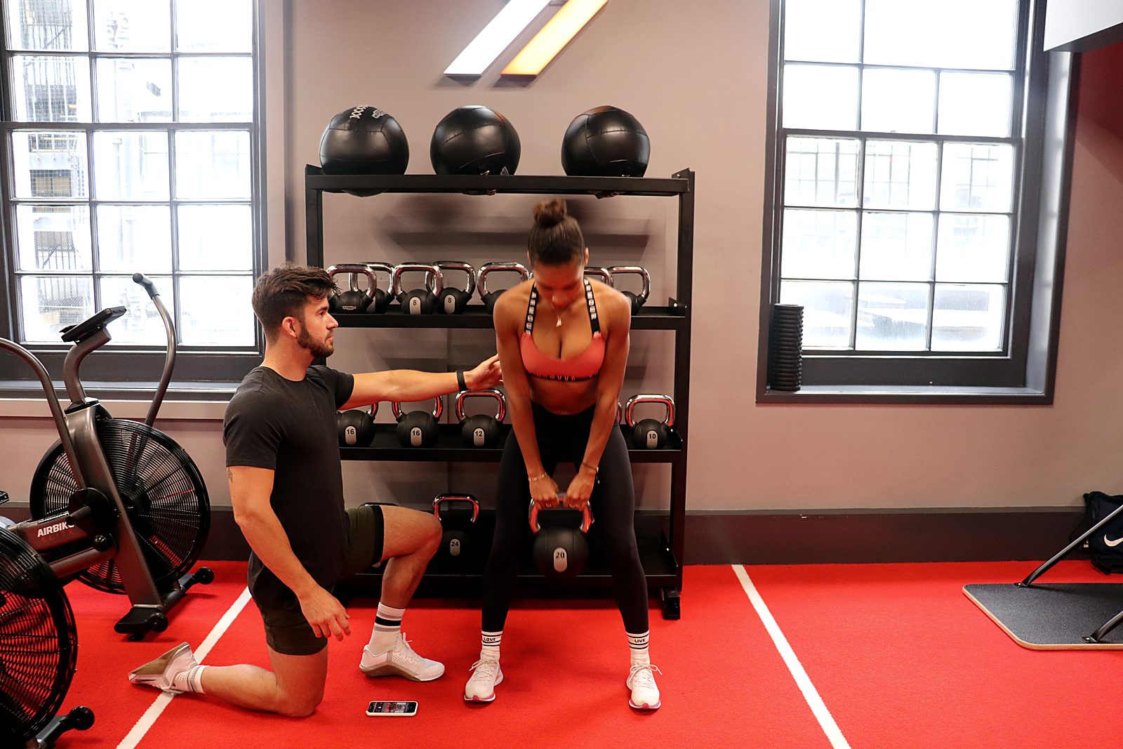 Personal trainer coaching a client through a kettlebell exercise