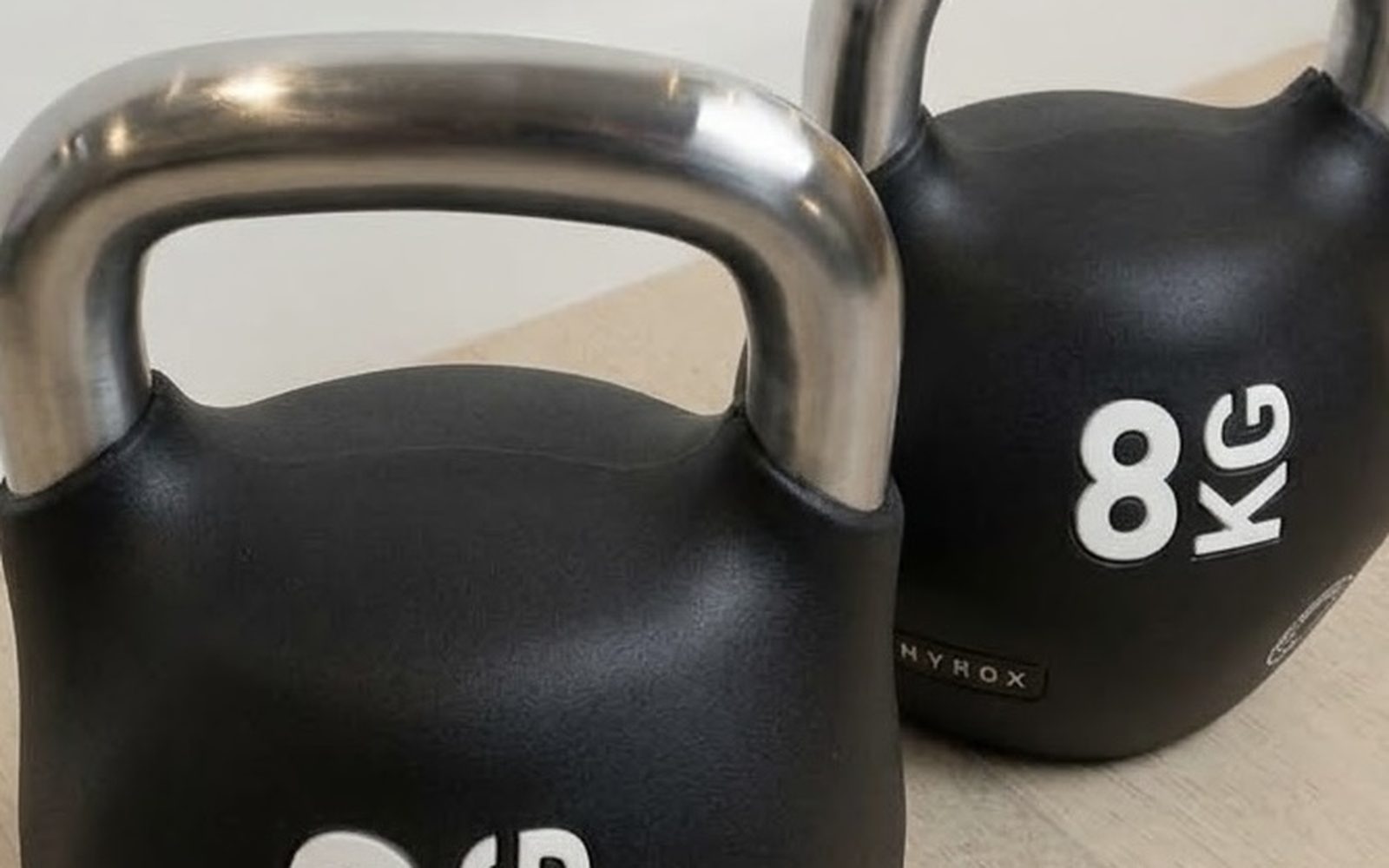 Two black 8kg competition kettlebells used for strength training on GLP-1 medication
